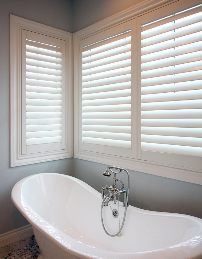 bathroom with stand alone bath tub and interior shutters in San Antonio