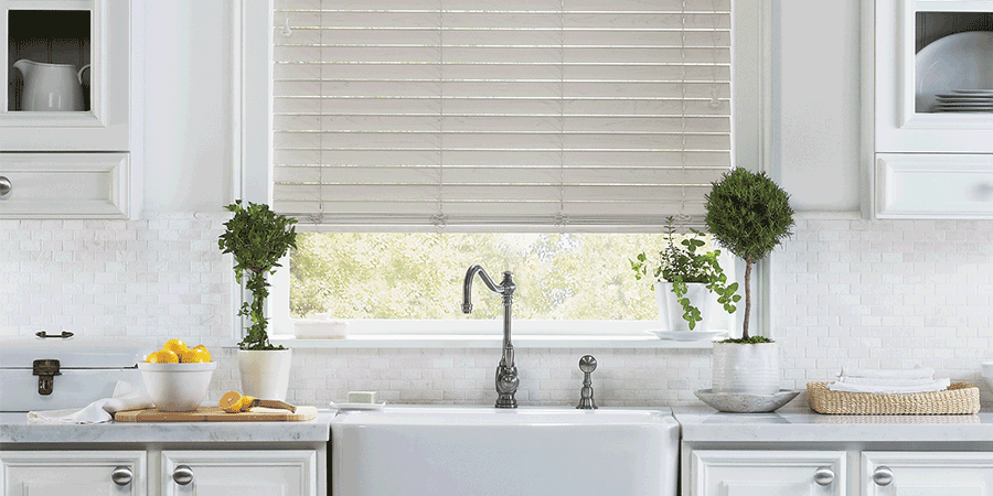 Farmhouse window treatments above kitchen sink in San Antonio home.