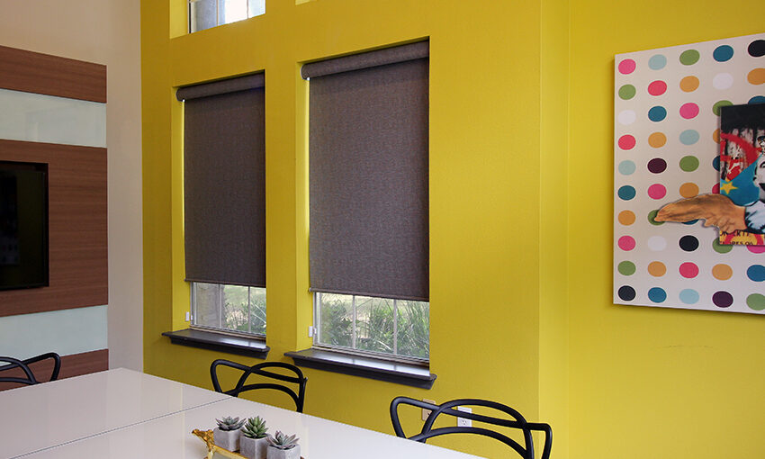 yellow office with polka dot wall art and hunter douglas designer roller shades San Antonio