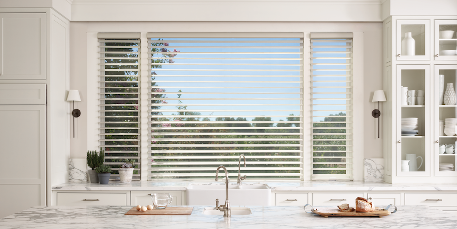 Kitchen sink with window above features nature-inspired sheer Hunter Douglas shades