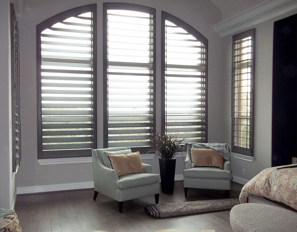 large arched window in San Antonio TX living room with real wood shutters