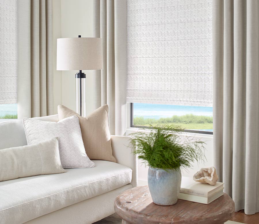 neutral living room with drapery and shades on window