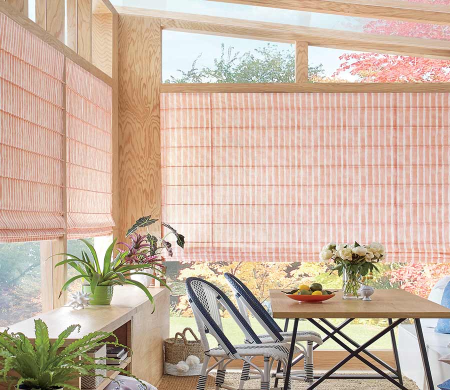 backyard oasis with coral colored roman shades