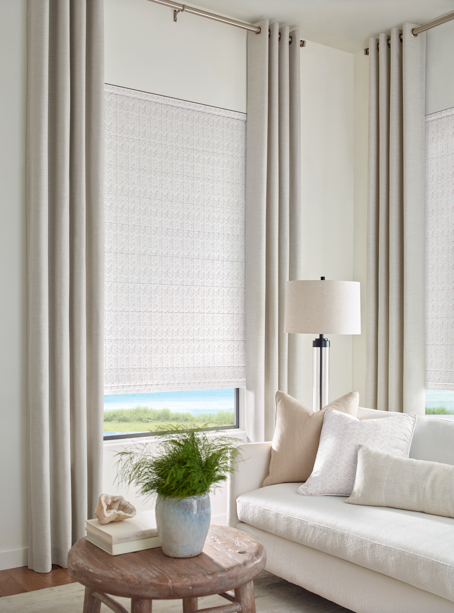 neutral living room with draperies and fabric roman shades