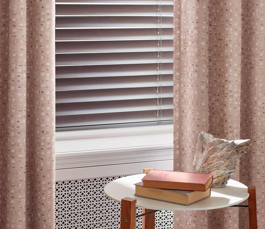 soft blush drapes with square patterns with rose gold aluminum blinds in Austin, TX