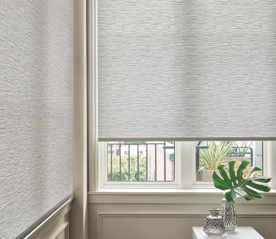 white designer roller shades on corner window