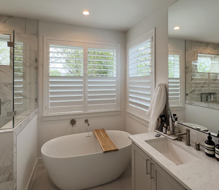 Custom white plantation shutters in Texas bathroom improving privacy and insulation