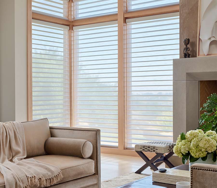 Silhouette sheer shades by Hunter Douglas installed on large corner windows, filtering sunlight in a bright, contemporary living space